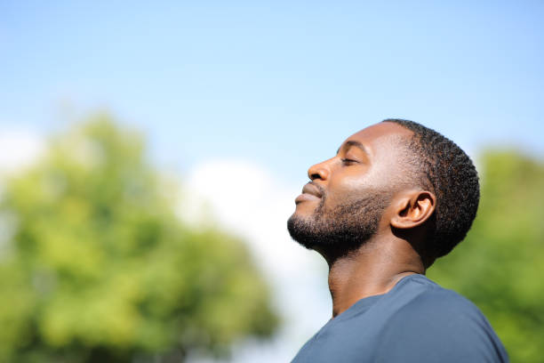 Profile of a black man breathing fresh air in nature