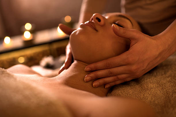 Close-up of young African American woman enjoying at spa during neck massage.